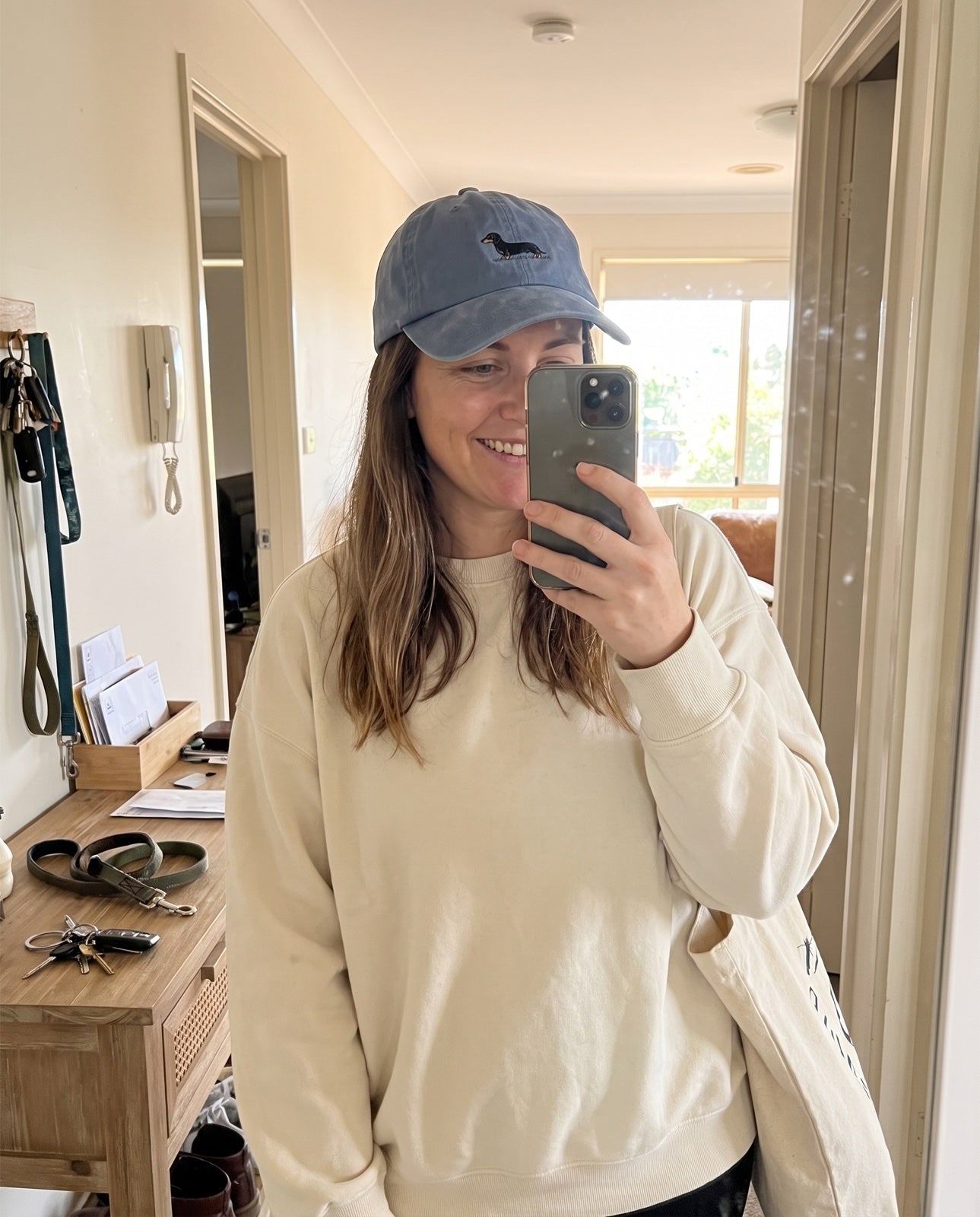 Lauren taking a mirror selfie in the washed-blue Dachshund Cap