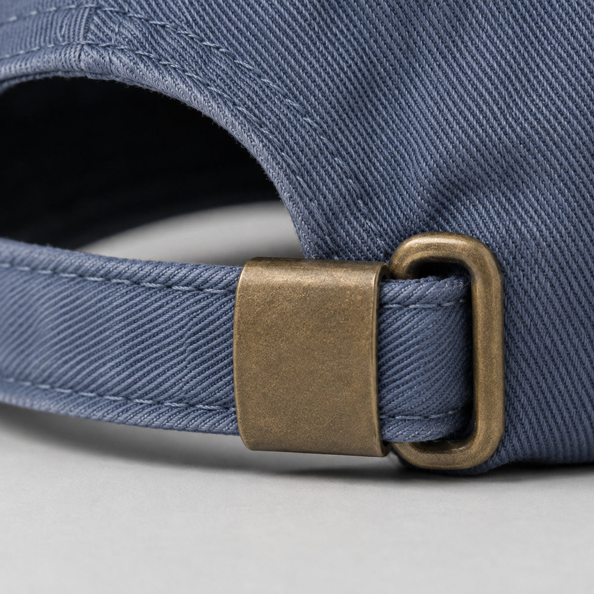 Close-up of the solid brass adjustable buckle on the back of the washed-blue Dachshund Cap
