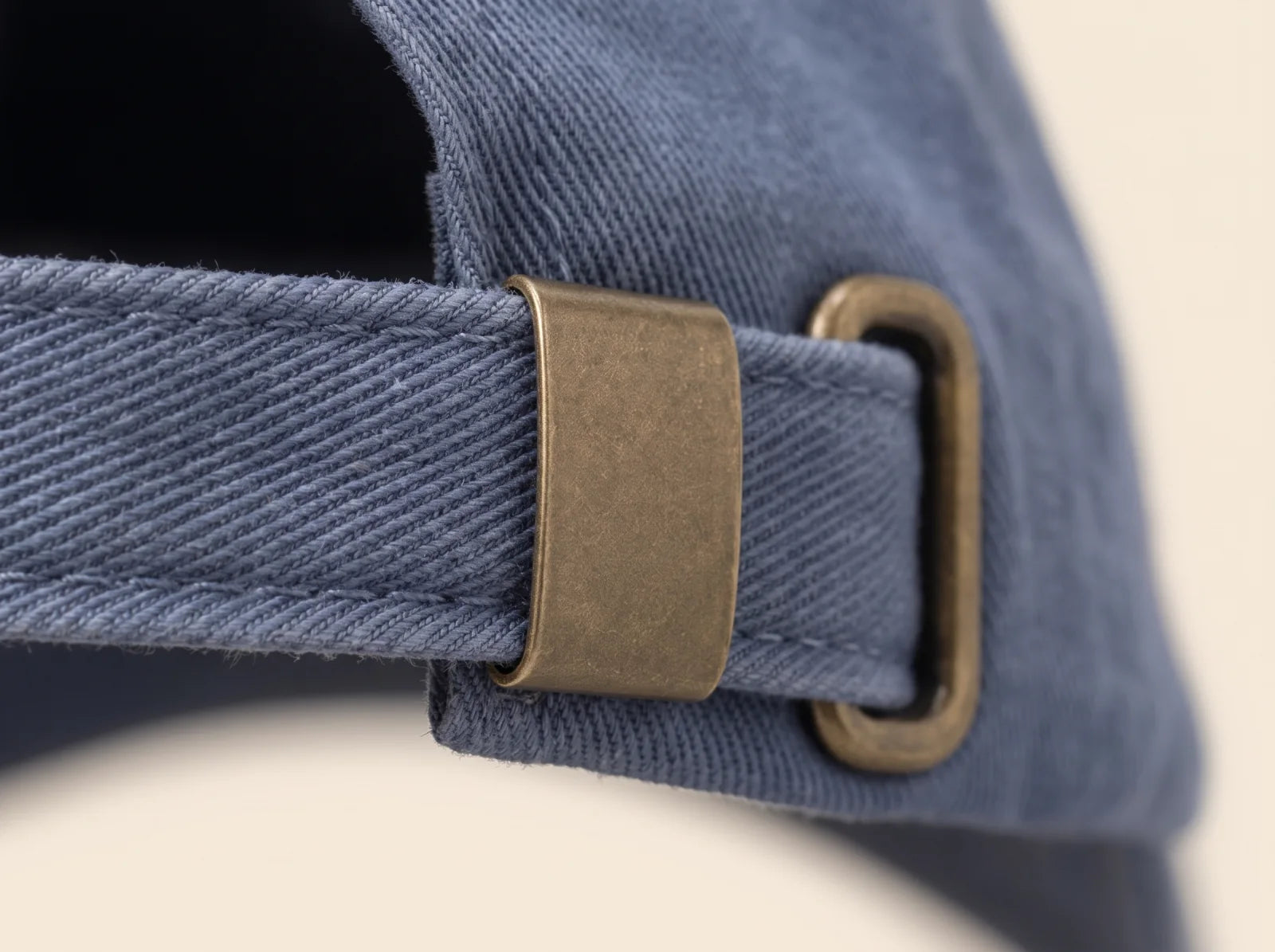 Close view of the aged solid brass closure and washed blue fabric strap