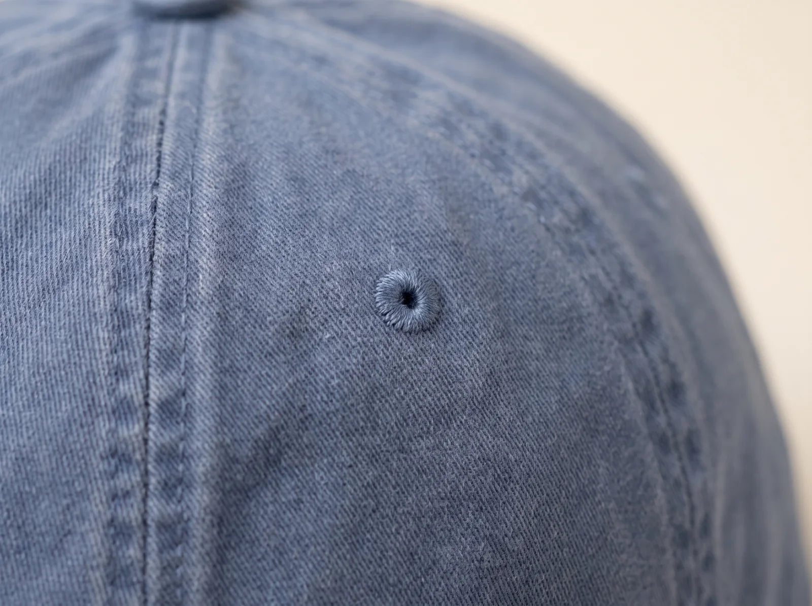 Close view of the washed blue cotton twill, panel seam and embroidered eyelet